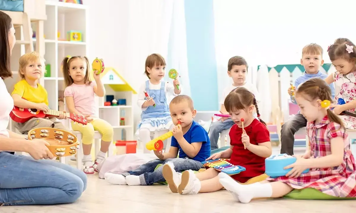 Wesołe zabawy w przedszkolu: dzieci grają na instrumentach, śpiewają i bawią się w rytm muzyki.