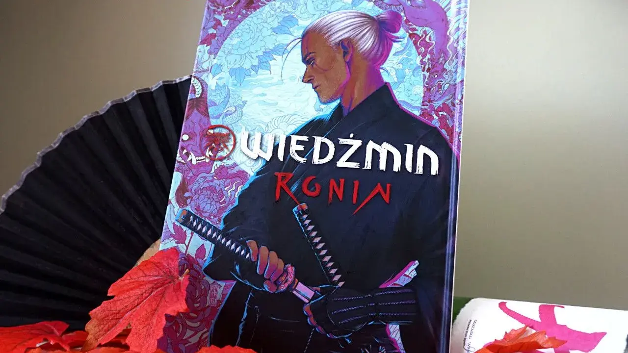 Komiks "Wiedźmin: Ronin" z Geraltem w japońskim stylu, otoczony jesiennymi liśćmi i wachlarzem.