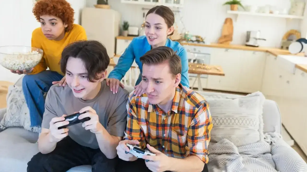 Młoda steam rodzina gra w gry wideo, jedząc popcorn.