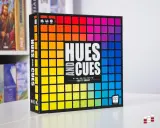 Gra planszowa "Hues and Cues" z tęczową paletą barw na okładce. Odkryj subtelne odcienie i wskazówki, by wygrać!