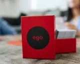 Czerwone pudełko gry "ego" z czarnym kołem i napisem "ego" w środku. Obok stos kart. Czas na ego gold pytania!