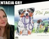 Kobieta prezentuje grę planszową "Psi park" z wesołymi psami na okładce.