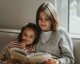 Mama czyta dziecku bajkę, pokazując, jak zachęcić dziecko do czytania. Wspólne chwile z książką budują więź i rozwijają wyobraźnię.