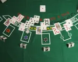 Stół do gry w blackjacka, karty i żetony. Widać karty z numerami i figurami, a także napisy "BLACKJACKS 3 TO 2" i "stand on all 17's".