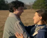 Mike i Eleven z Stranger Things 002 patrzą na siebie z czułością na tle polnej scenerii.