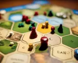Plansza do gry Catan, z pionkami i zasobami. Catan instrukcja jest kluczem do zwycięstwa.