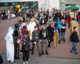 Tłum ludzi w kostiumach, w tym jednorożec i tygrys, na wydarzeniu Pyrkon. Co to za festiwal?