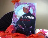 Komiks "Wiedźmin: Ronin" z Geraltem w japońskim stylu, otoczony jesiennymi liśćmi i wachlarzem.