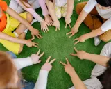 Dzieci tworzą krąg, pokazując palcami cyfry. To spokojne zabawy wyciszające Montessori, rozwijające koncentrację i współpracę.