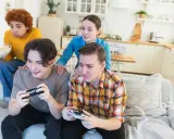 Młoda steam rodzina gra w gry wideo, jedząc popcorn.