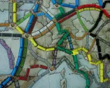 Planszowa mapa Europy z kolorowymi wagonikami. Która trasa jest najlepsza, by wsiąść do pociągu i odkryć nowe miasta?