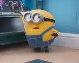 Minionek w ogrodniczkach zastanawia się, po jakim języku mówią minionki, gdy patrzy na automat z przekąskami.