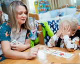 Kreatywne zabawy dla dzieci w wieku szkolnym: mama z synkiem grają w memory, rozwijając pamięć i spostrzegawczość.