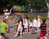 Animator wypuszcza balony, dzieci łapią je z radością. Świetny pomysł na urodziny dla dzieci na świeżym powietrzu!
