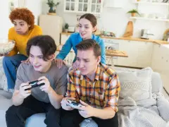 Młoda steam rodzina gra w gry wideo, jedząc popcorn.