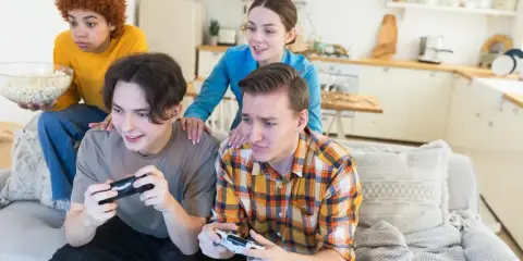 Młoda steam rodzina gra w gry wideo, jedząc popcorn.
