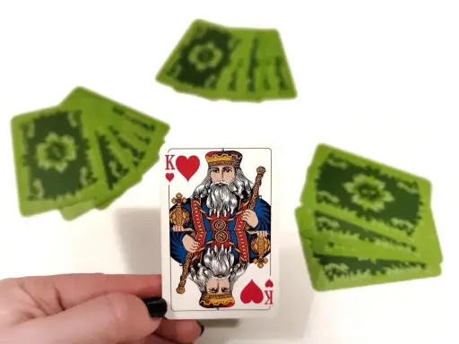 Król kier, a za nim stos zielonych kart. Czyżby to była gra w "Dupa biskupa"?