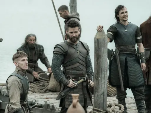Bohaterowie The Last Kingdom w zbrojach i z bronią, gotowi do walki na statku.