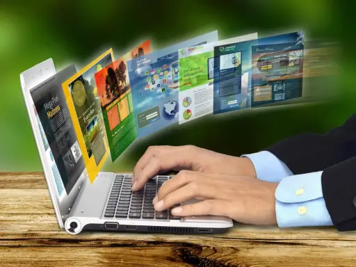 Dłonie piszą na laptopie, z którego wychodzą strony internetowe. To przykład, jak retoryka co to, czyli sztuka perswazji, działa w sieci.