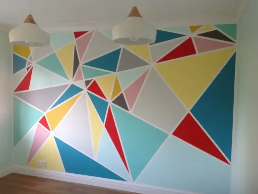 Kolorowe malunki na ścianie dla dzieci w geometryczne wzory. Radosna, pastelowa paleta barw tworzy wesołą atmosferę.