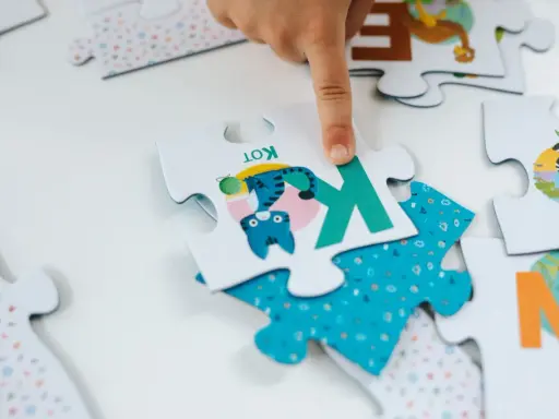 Dziecko układa puzzle dla 6 latka. Na jednym elemencie jest kotek, na innym zebra. Ile elementów?