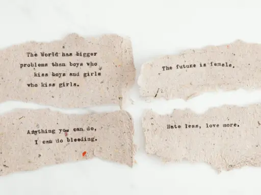 Mądre cytaty z książek na postrzępionych skrawkach papieru: "The future is female", "Hate less, love more".