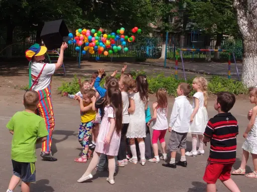 Animator wypuszcza balony, dzieci łapią je z radością. Świetny pomysł na urodziny dla dzieci na świeżym powietrzu!