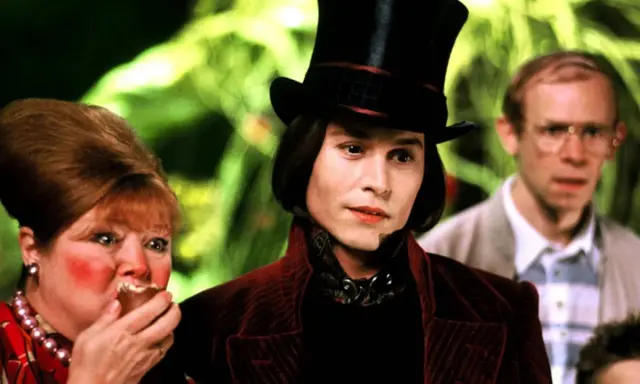 Johnny Depp jako Willy Wonka w filmie. Obok niego Veruca Salt i jej ojciec.