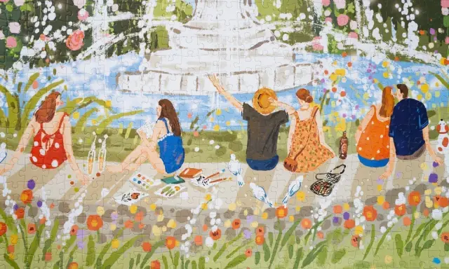 Ukladanie puzzli krajobrazy: letni piknik nad wodą, ludzie odpoczywają wśród kwiatów, malują i rozmawiają.