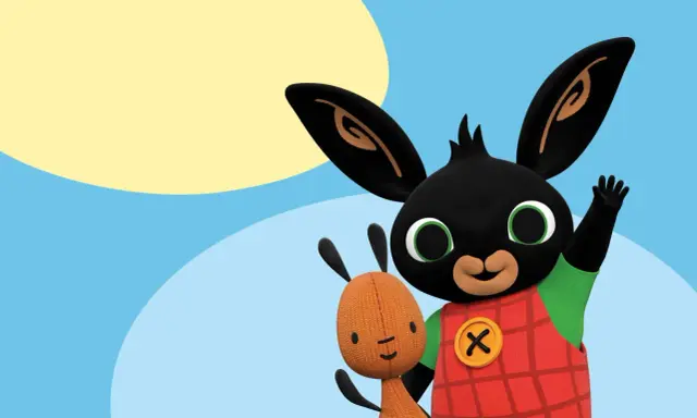 Bing i jego przyjaciel Flop, uśmiechnięte bing postacie, machają na tle błękitnego nieba i żółtego słońca.