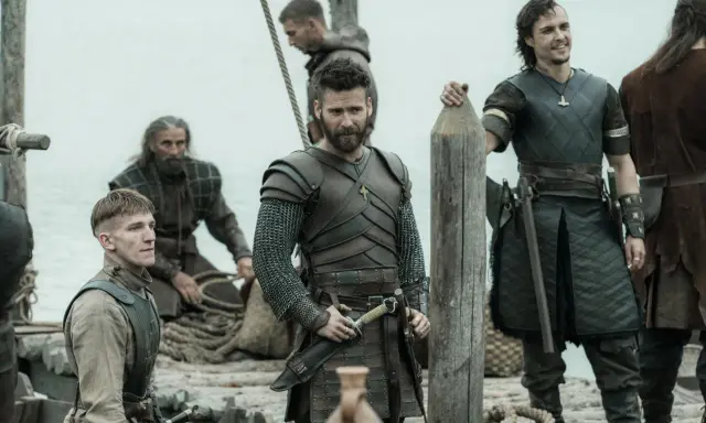 Bohaterowie The Last Kingdom w zbrojach i z bronią, gotowi do walki na statku.