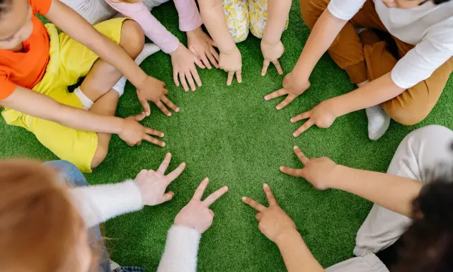 Dzieci tworzą krąg, pokazując palcami cyfry. To spokojne zabawy wyciszające Montessori, rozwijające koncentrację i współpracę.
