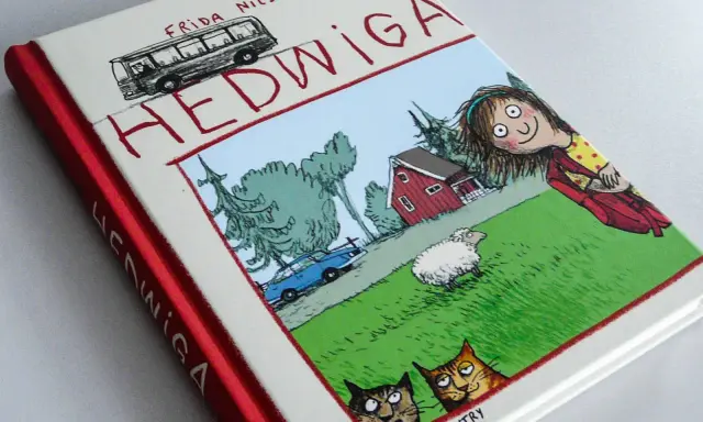 Okładka książki "Hedwiga" Fridy Nilsson, idealna dla 7 latka. Zabawna ilustracja z dziewczynką, owcą, kotami i autobusem.