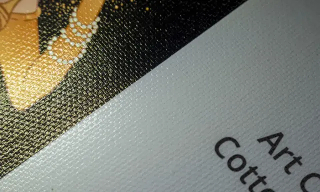 Fragment złocistego wzoru na czarnym tle, obok biały, fakturowany **canvas** z napisem "Art Cotton".