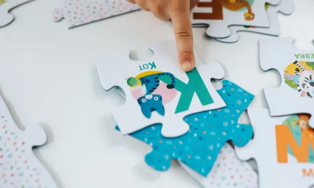Dziecko układa puzzle dla 6 latka. Na jednym elemencie jest kotek, na innym zebra. Ile elementów?