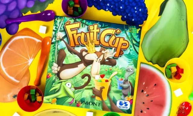 Gra Fruit Cup z owocami i kostkami. Małpa w koronie miesza owocowy deser.