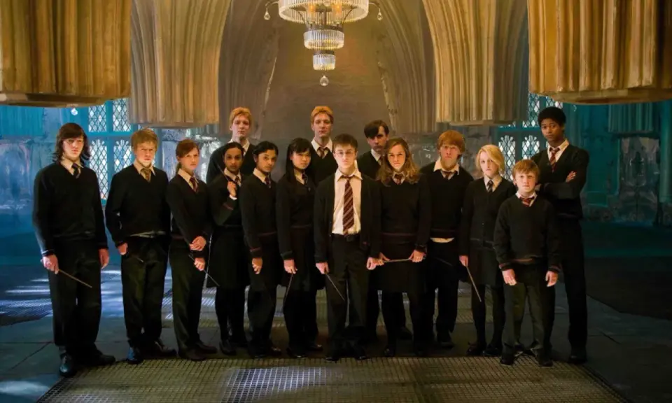 Grupa uczniów z domu Hufflepuff, w tym Harry Potter, stoi w eleganckiej sali.