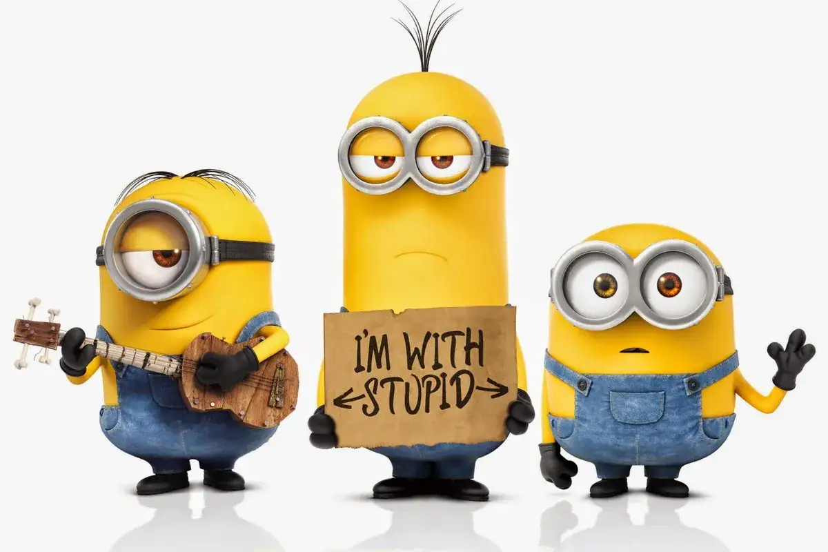 Trzech minionk&oacute;w. Jeden gra na ukulele, drugi trzyma tabliczkę 