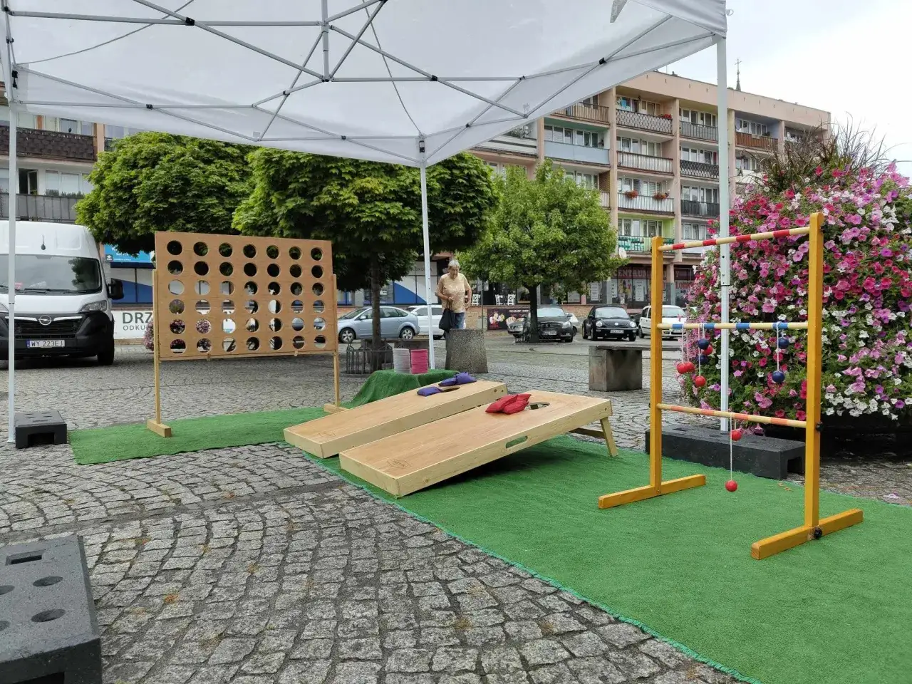 Gry i zabawy na świeżym powietrzu: wielkie kółko, cornhole i ladder toss. Idealne konkurencje sportowe dla dorosłych na letnie popołudnie.