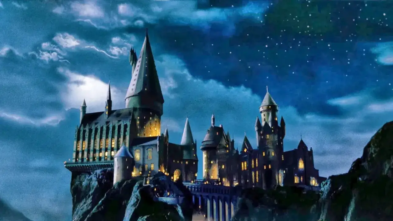 Hogwart, magiczna szkoła z uniwersum Harry'ego Pottera, w blasku księżyca i gwiazd.