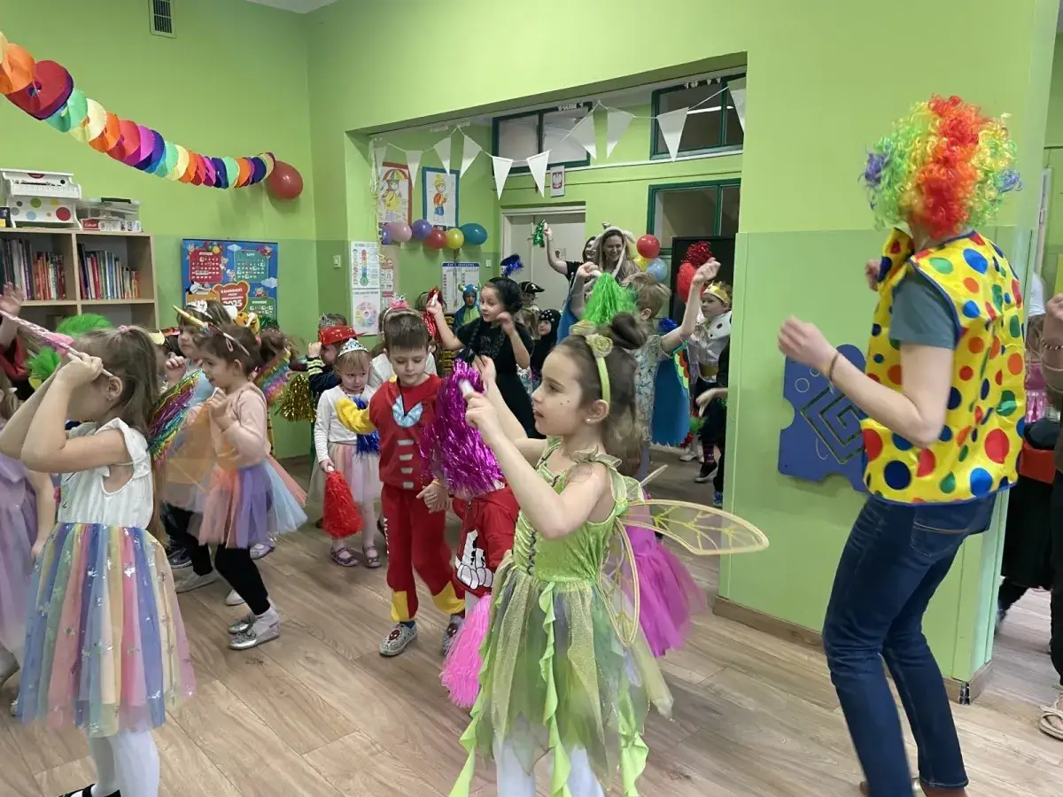 Dzieci w barwnych strojach wr&oacute;żek i superbohater&oacute;w bawią się na balu karnawałowym. Wesołe zabawy na balu karnawałowym dla dzieci trwają w najlepsze!