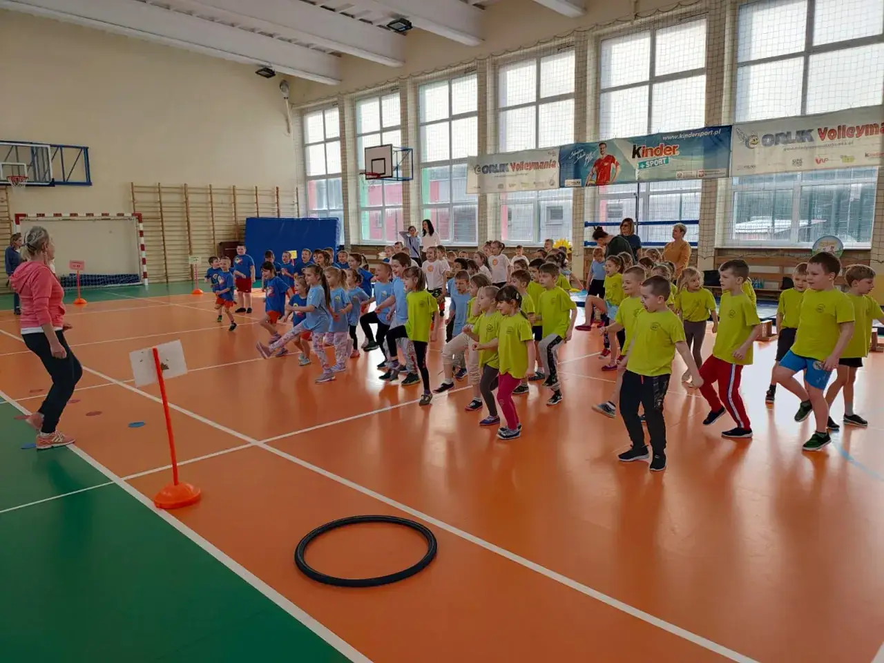 Dzieci klas 1-3 biorą udział w wesołych grach i zabawach ruchowych na sali gimnastycznej.