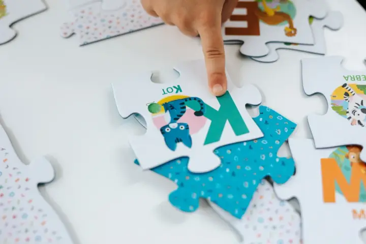 Dziecko układa puzzle dla 6 latka. Na jednym elemencie jest kotek, na innym zebra. Ile elementów?